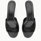 The Staud Brigitte Satin Mule is a black open-toe heeled mule with a wide front strap and stitched insole, perfect for versatile dressing, shown against a white background.