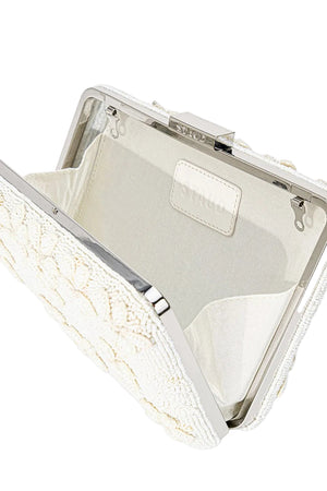 The Staud Carmella Beaded Clutch features an open, asymmetrical shape with white beads, a silver metal frame, light fabric lining, and a small inner pocket.