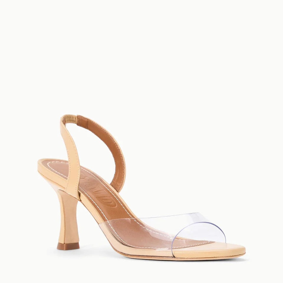 The Staud Brigitte Heel is a beige nappa leather sandal featuring an open toe, clear front strap, and comfortable elastic slingback.
