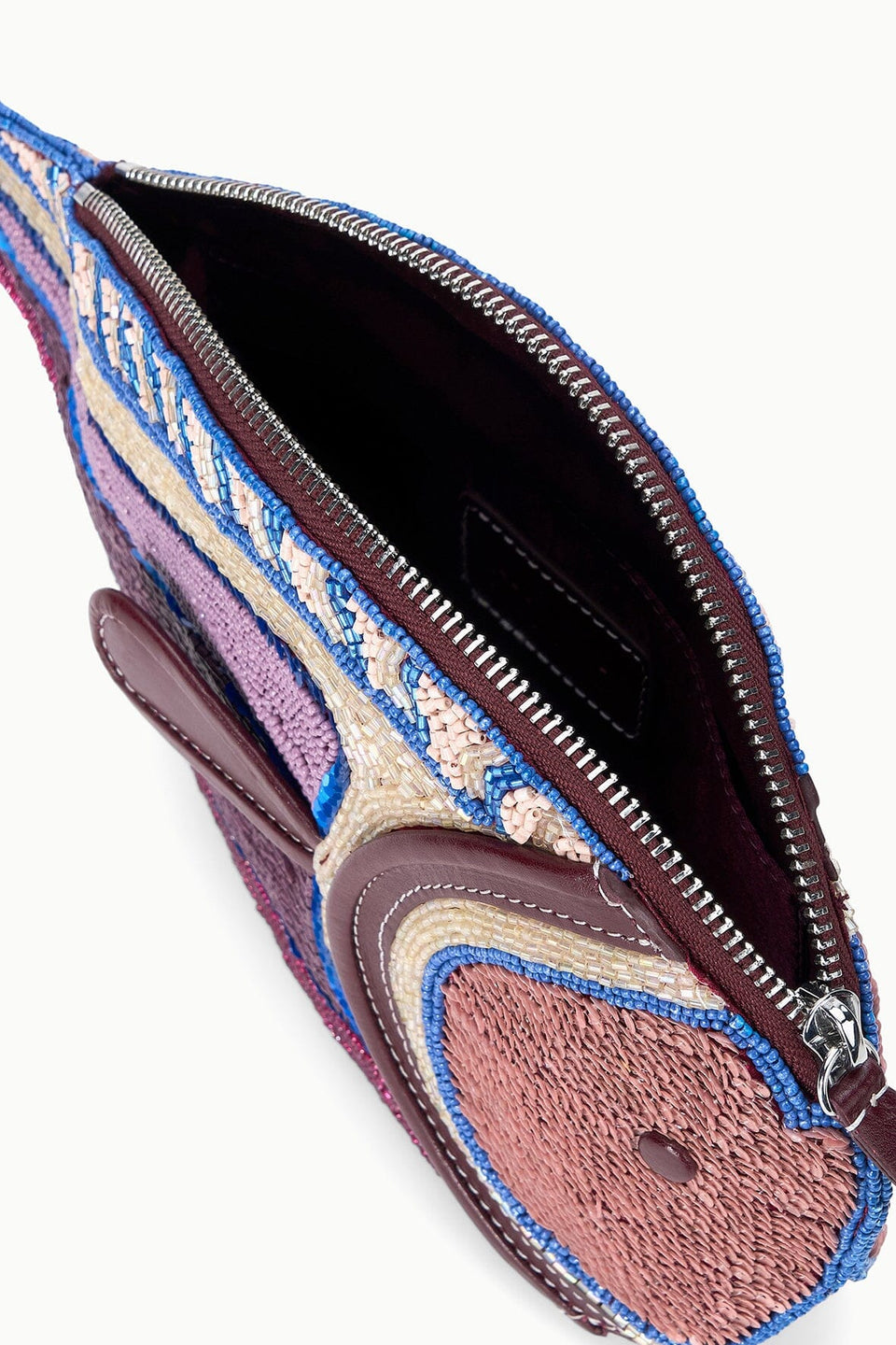 Close-up of the Staud Pesce Clutch, showing its multicolored textured fabric and leather details. The open zip closure reveals the interior lining and a small inner pocket.