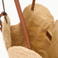 The Staud Large Palm Raffia Bag features open woven straw construction with brown leather shoulder straps and a light tan fabric lining, shown from above to highlight the spacious interior of this elegant carryall.
