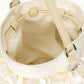 The Lila Mini Bag by Staud is a cream-hued evening bag featuring sequin accents, dual handles, metal hardware, and an open view of its empty beige interior with visible stitching.