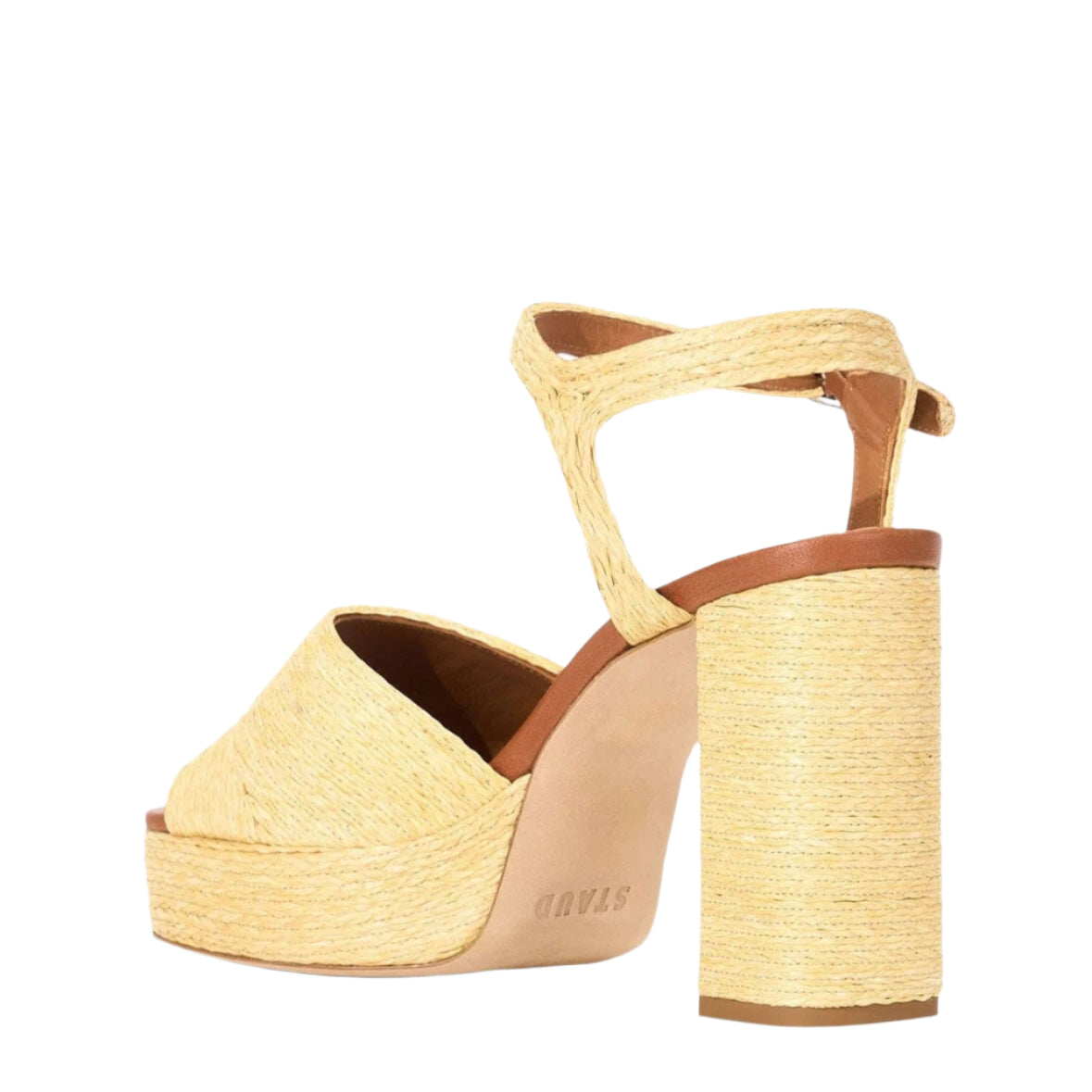 The Staud Jodie Platform Heel is a high-heeled sandal with a chunky block heel, square toe, ankle strap, and woven raffia texture in natural beige.