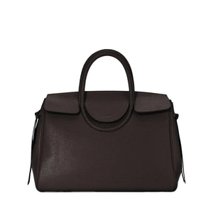 The Staud Maude Carryall is a dark brown pebbled leather handbag featuring a structured shape, top handle, flap closure, and minimal front branding.