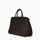 The Staud Maude Carryall, a dark brown pebbled leather handbag with round top handles and a side knot detail, is shown against a plain white background.