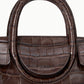 Close-up of a brown croc-embossed leather Staud Maude Mini Carryall with a rounded top handle and a fold-over flap.