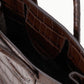 Top-down view of a dark brown croc-embossed leather Staud Maude Mini Carryall with dual handles.