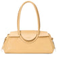 The Maude Shoulder Bag, made from polished beige leather, has long handles and a secure flap closure. "Staud" is elegantly embossed on the front.