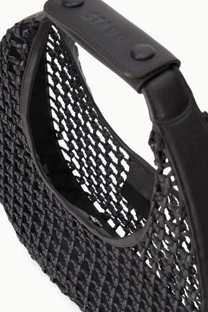 Close-up of the Staud Moon Hand-Knotted Tote Bag, a black crescent-shaped design with a structured handle and leather trim, highlighting its detailed texture and hand-knotted craftsmanship.