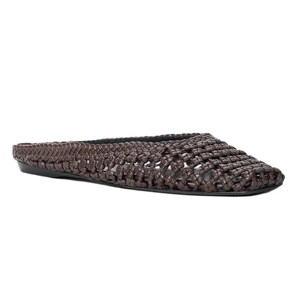 The Otto Hand-Knotted Flat Mule by Staud is a woven brown leather, closed-toe mule with a flat sole, shown against a white background.