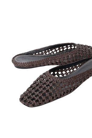 The Staud Otto Hand-Knotted Flat Mule features brown leather, pointed toes, an open basket-weave design, and a classic slip-on style.