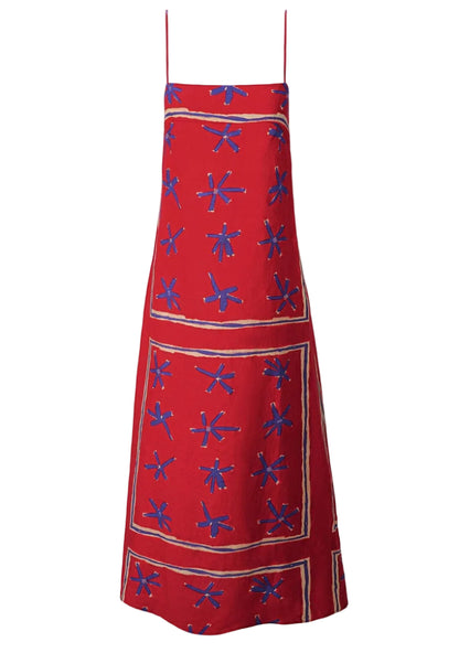 The Laura Linen Maxi Dress by Staud is a red summer dress with adjustable spaghetti straps, blue abstract floral patterns, and beige rectangular borders.