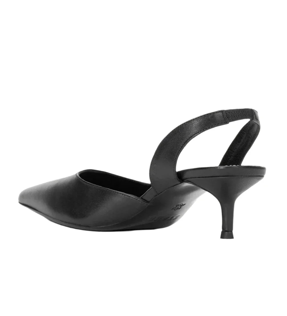 The Staud Sebastion Slingback, a sleek black heel crafted from luxurious nappa leather, showcases a pointed toe and thin heel, elegantly displayed from the side on a pristine white background.