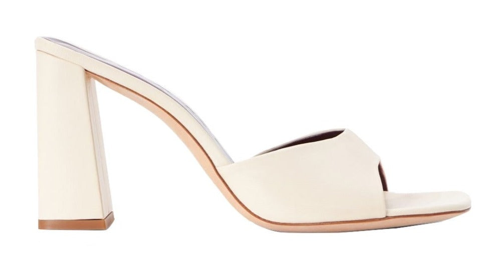 A white Staud Sloane Heel mule with a wooden heel, perfect for adding a touch of sophistication to any outfit.