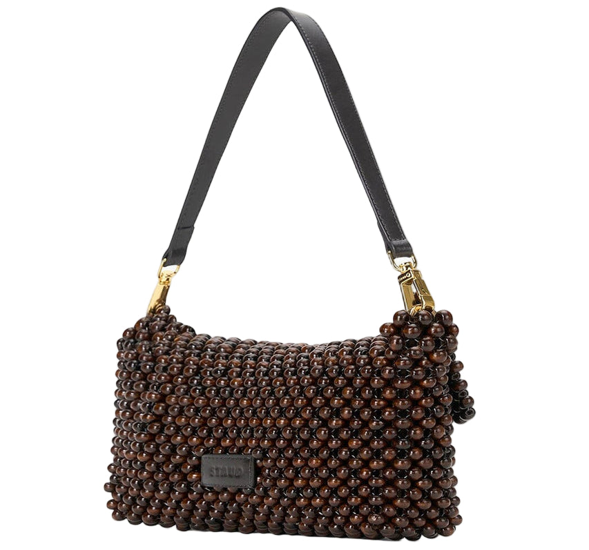 The Staud Timmy Convertible Shoulder Bag features dark brown wooden beads, a black leather strap, gold-tone hardware, and an interior zip pocket for secure storage.