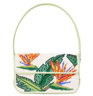 Introducing the Staud Tommy Beaded Bag, a stunning eco-friendly handbag made from vegan leather with a cream background and a hand-beaded floral design featuring green leaves and vibrant bird-of-paradise flowers. It includes a flap closure and a light green strap for added style.