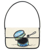 The Staud Tommy Beaded Bag is crafted from vegan leather and features hand-beading with an open caviar tin, small spoon, and caviar on a cream background, finished with a magnetic snap closure.