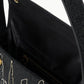 A close-up of the Staud Tommy Beaded Bag, an open vegan leather handbag featuring a city skyline bead design, magnetic snap closure, and a visible interior zip pocket.