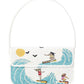 The Staud Tommy Beaded Bag in white vegan leather features three surfers riding waves under a yellow sun with black birds, and closes with a magnetic snap.