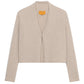 The Stealth Cardigan by Guest in Residence is a beige, cropped cashmere cardigan with long sleeves and an open front, shown against a white background.