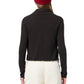 Model wears the Guest in Residence Stealth Cardigan over a black long-sleeve top, paired with white pants and a red beanie, shown from the back against a white background.