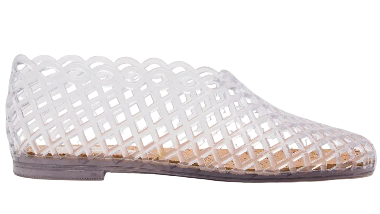The Steve Madden Kids Girls’ Grovee Jelly Flat is a clear plastic shoe featuring a lattice pattern and closed toe, shown in profile against a white background. This lightweight slip-on is perfect for kids, offering both style and convenience.