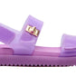 Introducing the Girls’ Jelly Mona Sandal by Steve Madden Kids—a stylish purple sandal featuring a trendy flatform design, adjustable straps, and a chic gold buckle detail on the side, perfect for your little fashionista.