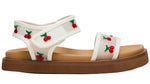 The Toddlers’ Lyla Sandal by Steve Madden Kids features a white footbed with a brown sole and embroidered cherries and green leaves on the straps, while adjustable Velcro straps ensure a comfortable fit.