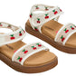 Introducing the Steve Madden Kids Toddlers’ Lyla Sandal: These sandals showcase a white footbed with tan soles and are adorned with embroidered cherry details on the straps and ankle bands. The design features adjustable Velcro straps, allowing for a customizable fit.