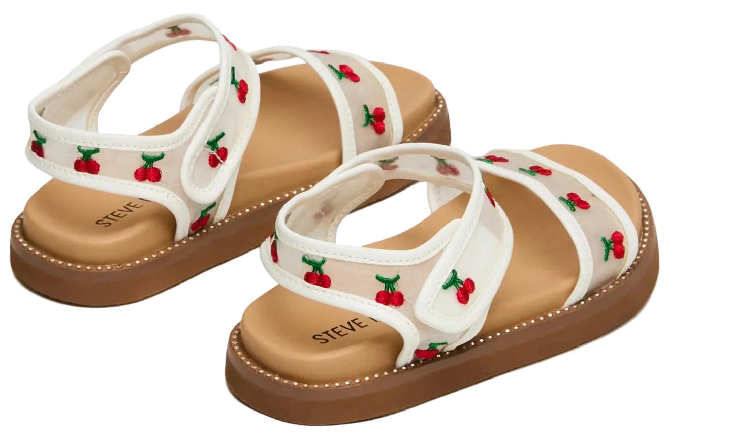 The Steve Madden Kids Toddlers’ Lyla Sandal features a white footbed with embroidered cherry details, brown soles, and adjustable Velcro straps, shown against a plain white background.