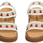 Introducing the Steve Madden Kids Toddlers’ Lyla Sandal—a stylish pair of footbed sandals featuring white adjustable Velcro straps with charming embroidered cherry details and comfortable tan soles.