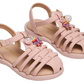 The Toddlers’ Pocket Charmed Sandal by Steve Madden Kids is a light pink strappy sandal for children, featuring buckle straps and a woven design adorned with decorative charms like a rainbow, unicorn, and faux pearls—an ideal choice for little ones.