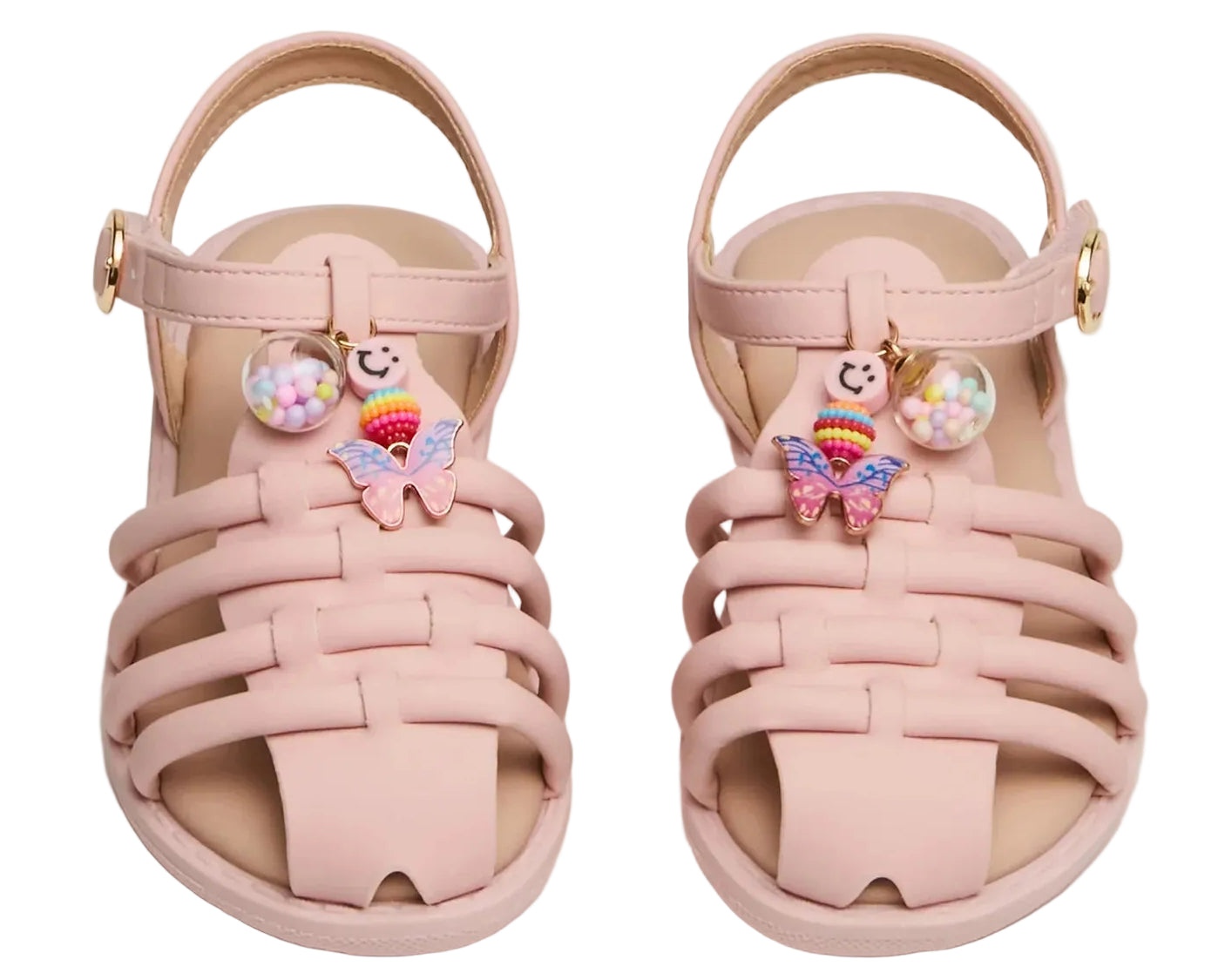 A pair of Steve Madden Kids Toddlers’ Pocket Charmed Sandals in pink, featuring strappy ankle straps and adorned with a butterfly charm and a smiley face charm filled with small colorful beads on each shoe.