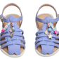 A pair of Toddlers’ Pocket Charmed Sandals by Steve Madden Kids, in lavender, featuring ankle straps and decorative charms—including beads, stars, and blocks spelling “LOVE.”.