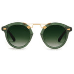 The Krewe STL II Sunglasses feature green round lenses with a gold metal bridge and accents, oversized silhouette, dark green gradient lenses, and black temple arms—evoking French Quarter cast-iron balconies. Displayed on a white background.