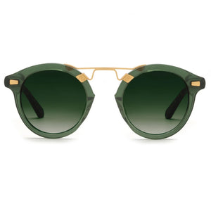 The Krewe STL II Sunglasses feature green round lenses with a gold metal bridge and accents, oversized silhouette, dark green gradient lenses, and black temple arms—evoking French Quarter cast-iron balconies. Displayed on a white background.