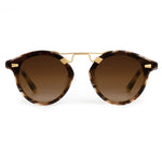 Krewe STL Nylon Sunglasses feature a round, oversized tortoiseshell-patterned frame, brown gradient flat nylon lenses, and gold metal accents on the bridge, shown from the front.