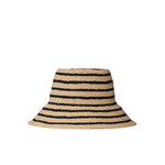 The Janessa Leone Felix Harbor Hat is a wide-brimmed, hand-crocheted straw hat featuring black horizontal stripes on a natural beige base, shown against a white backdrop.