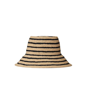 The Janessa Leone Felix Harbor Hat is a wide-brimmed, hand-crocheted straw hat featuring black horizontal stripes on a natural beige base, shown against a white backdrop.