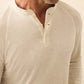 A man wearing a light-colored Faherty Long-Sleeved Cloud Henley with three buttons undone, shown from shoulders to mid-torso.