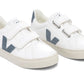 The Veja Junior Esplar Velcro Chromefree Leather Sneaker by Veja is a pair of white sneakers made with ChromeFree leather, featuring two velcro straps and gray 'V' logos on the sides, complemented by gray heel patches.