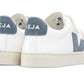 A pair of Veja Junior Esplar Velcro ChromeFree Leather Sneakers featuring white uppers, beige soles, and blue-gray suede accents on the heel and side, crafted by the brand Veja.