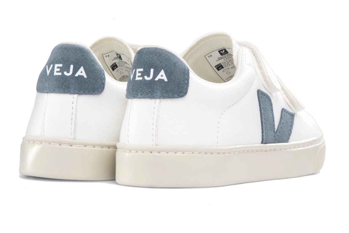 A pair of Veja Junior Esplar Velcro ChromeFree Leather Sneakers featuring white uppers, beige soles, and blue-gray suede accents on the heel and side, crafted by the brand Veja.