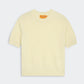 The Guest in Residence Sweater Tee is a short-sleeve, pale yellow jersey crewneck featuring ribbed collar, cuffs, and hem, shown flat on a plain background.