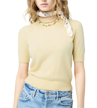 Woman wearing a light yellow Sweater Tee by Guest in Residence, blue jeans, a printed neck scarf, and a beaded necklace.