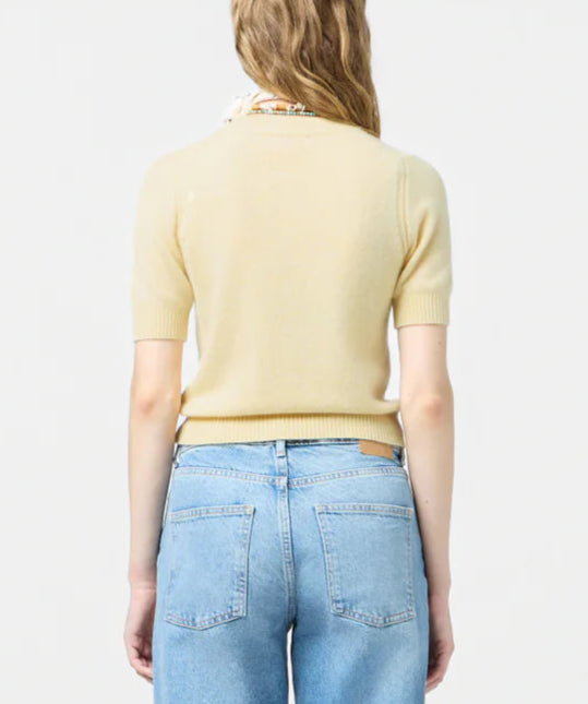 A person with long, wavy hair is shown from the back, wearing a light yellow Guest in Residence Sweater Tee and light blue jeans against a plain background.