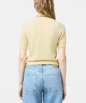 A person with long, wavy hair is shown from the back, wearing a light yellow Guest in Residence Sweater Tee and light blue jeans against a plain background.