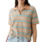 A woman wears the Short Sleeve Stripe Rugby by Guest in Residence, styled over a tee and paired with light blue jeans.