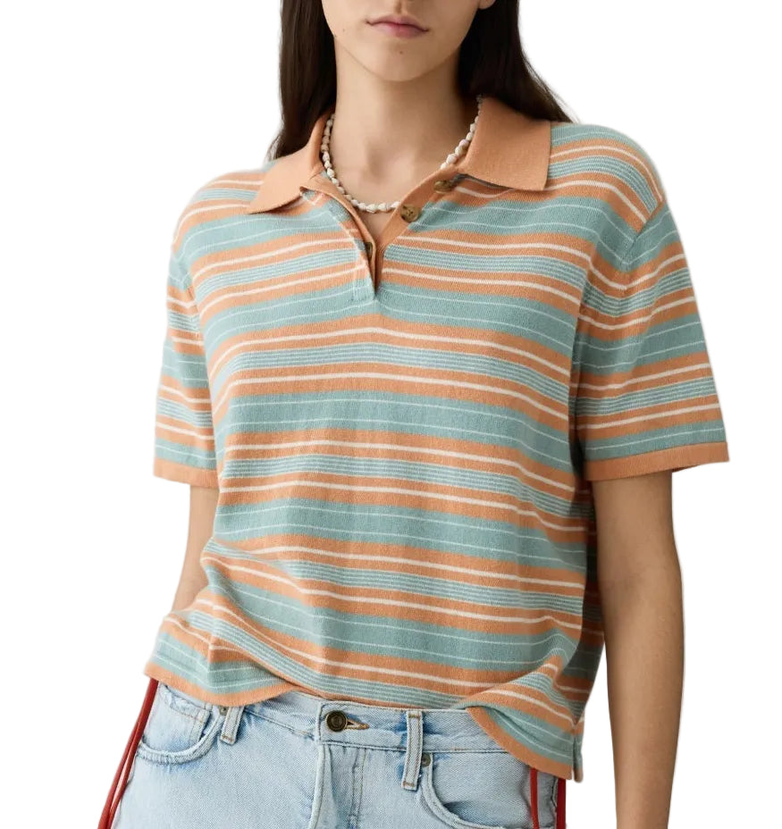 A woman wears the Short Sleeve Stripe Rugby by Guest in Residence, styled over a tee and paired with light blue jeans.