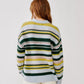 A person with long, reddish hair is seen from behind against a plain white background, wearing the Billie Sweater by Sablyn—a loose cashmere sweater featuring green, yellow, white, and pale pink stripes.